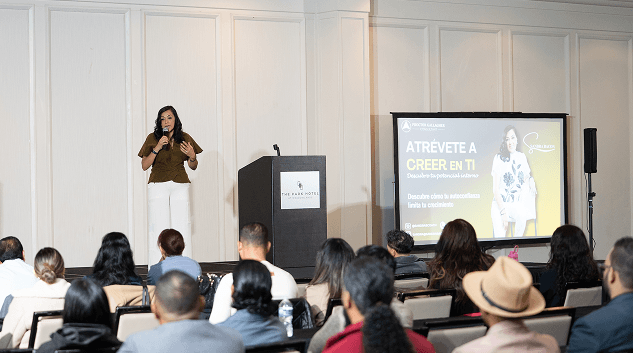 Speaker giving a motivational talk to an audience at a Transformando Comunidades event