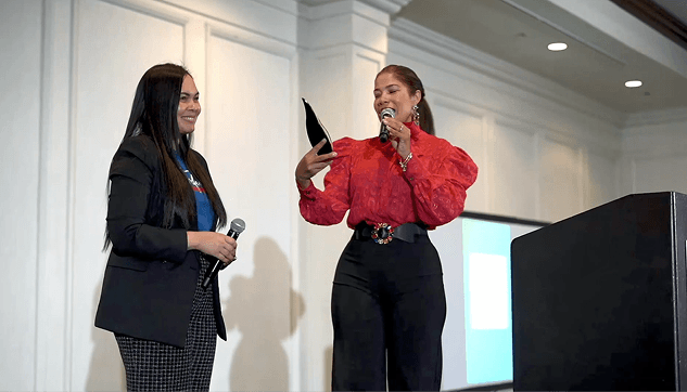 Two women on stage during a Transformando Comunidades recognition event